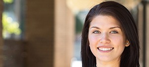 Woman in blue smiling outside