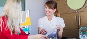 dental team member showing paperwork to a patient 