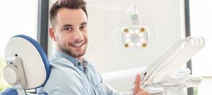 man giving a thumbs-up in the dental chair 