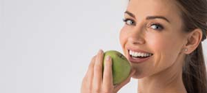 woman eating a green apple 