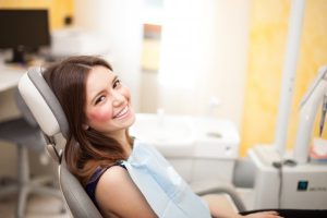 A woman smiling in a dental chair.