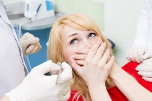 Woman covering her mouth is concerned about a root canal in Lenox Hill