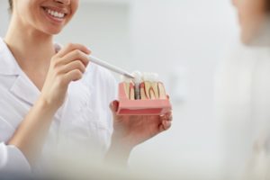 dentist showing a model of dental implants at a dental implant consultation 